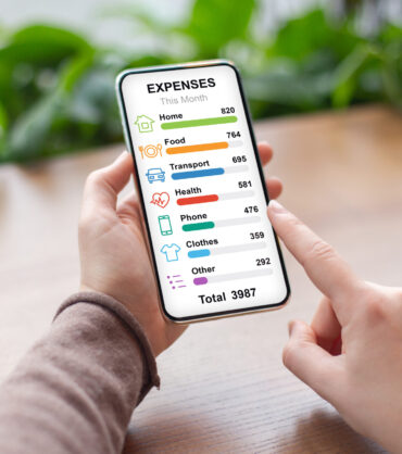 Unrecognizable woman checking her montly expenses by categories while having coffee break at cafe, using newest financial mobile application on smartphone, copy space, creative image