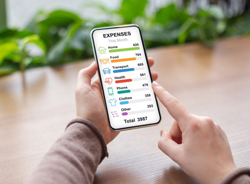 Unrecognizable woman checking her montly expenses by categories while having coffee break at cafe, using newest financial mobile application on smartphone, copy space, creative image