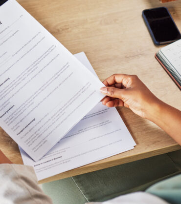 Family lawyer, hands and contract with attorney case and custody notes with agreement in a office. Desk, top view and law firm with planning and paperwork for report and document with child services