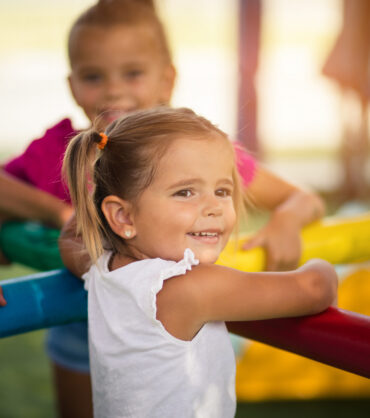 It's always important to have someone close to you. Three little girls playing in playground. Space for copy. Focus in foreground.