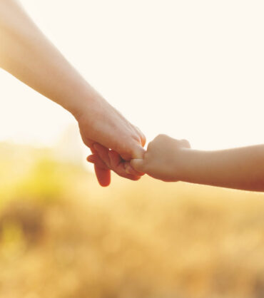 Family values. The father holds his daughter's hand. Hand in hand. Child support. Walk at sunset.