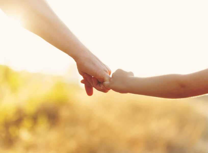 Father holds his daughter's hand Family values. The father holds his daughter's hand. Hand in hand. Child support. Walk at sunset.